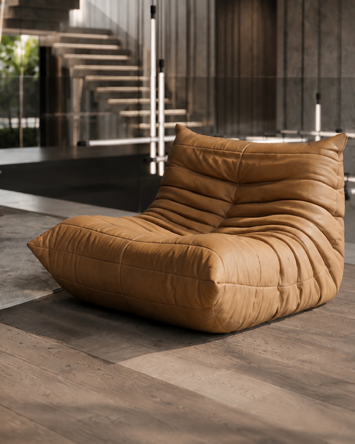 The full Togo lounge chair in cognac leather, showing its quilted, folded surface