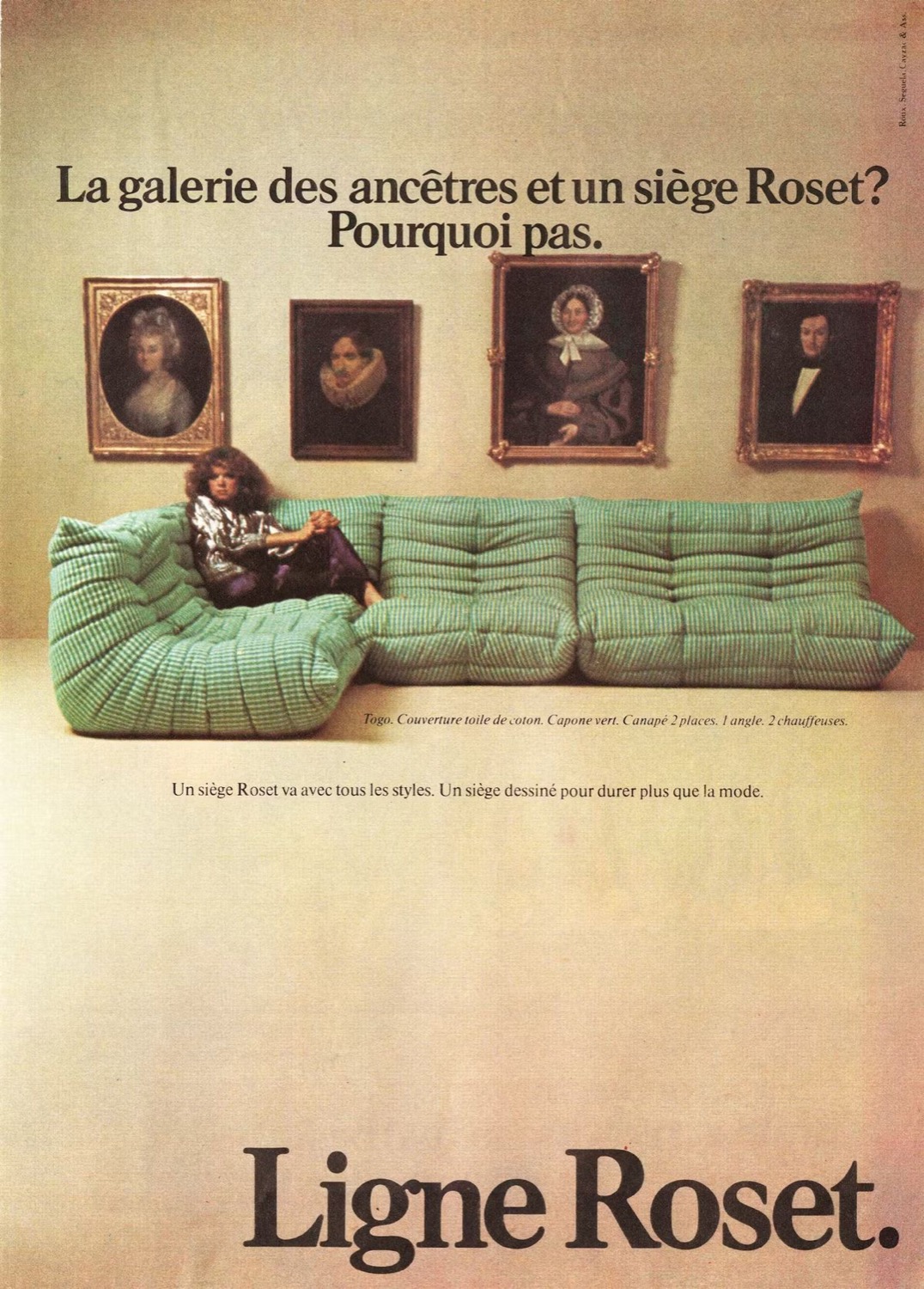 Vintage Ligne Roset advertisement: a green Togo beneath a wall of ancestral portraits